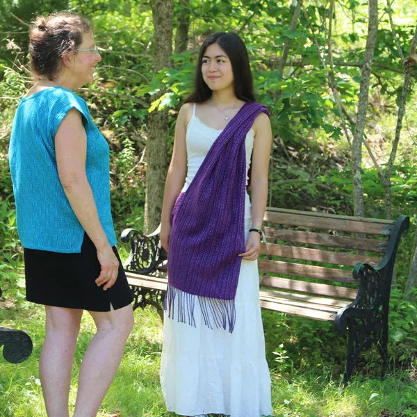 Young woman in a side-draped purple poncho talking with Frances