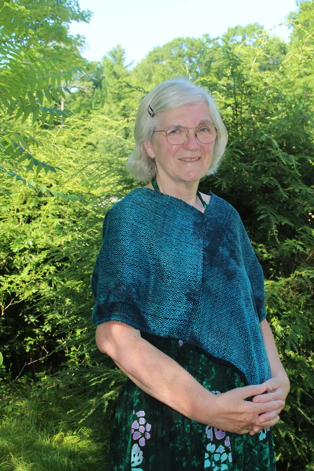 Woman wearing a deep teal chenille infinity poncho